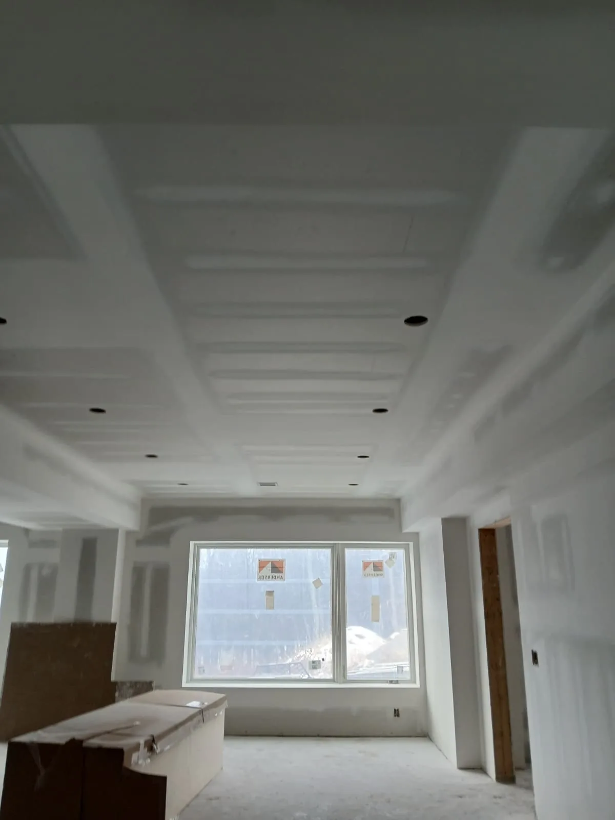 Drywall taped and coated in a new room before paint
