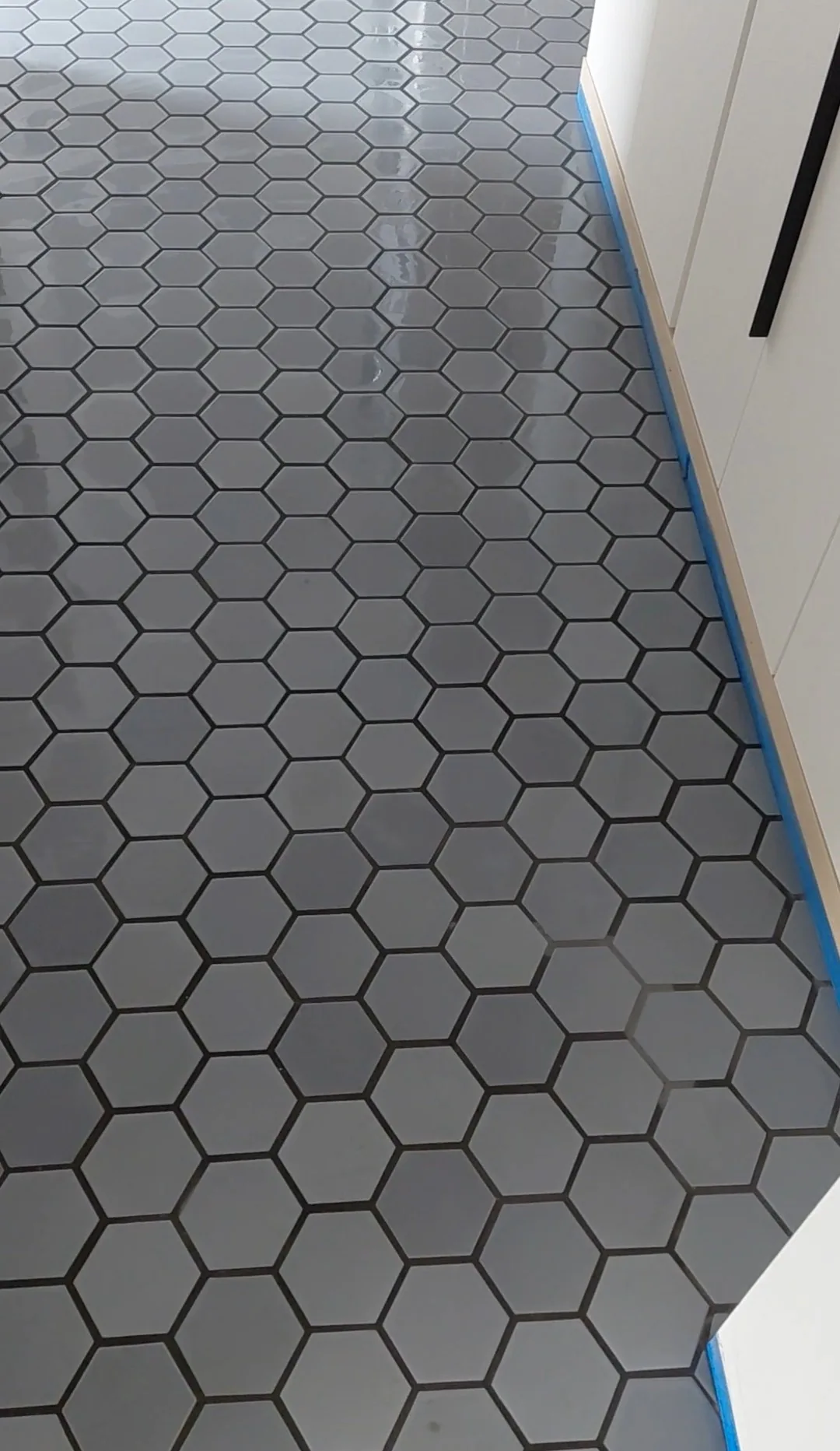 Hexagon tile floor with dark grout finished clean