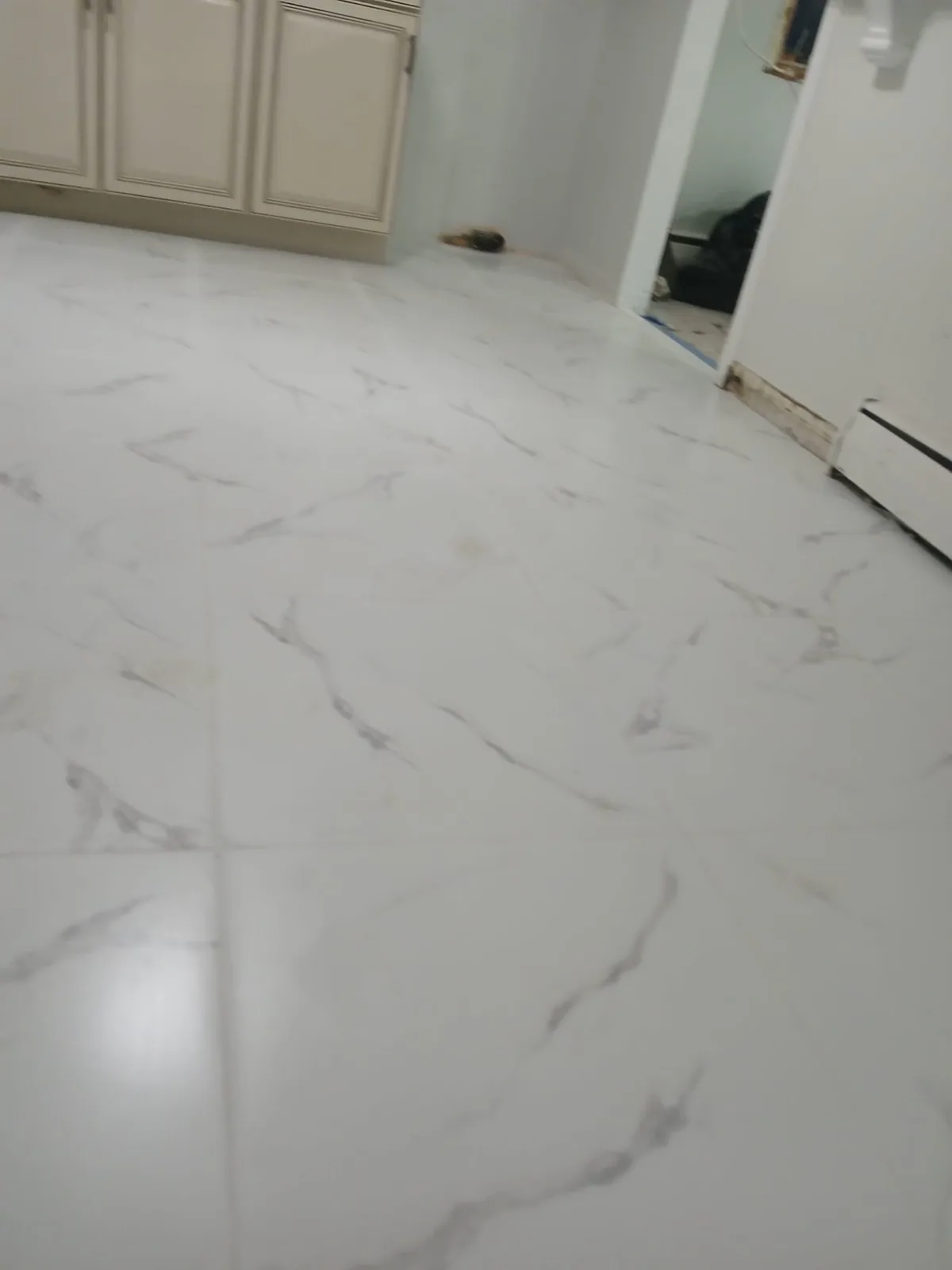 Large-format marble-look tile floor freshly grouted