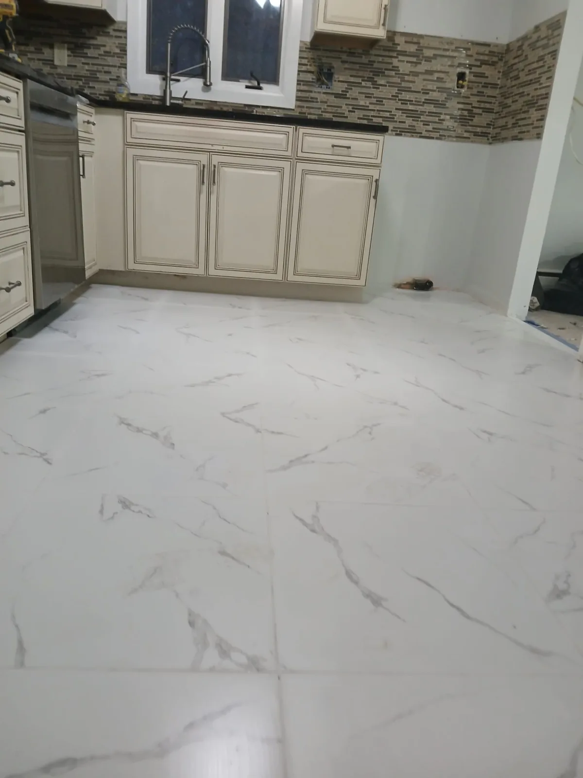 Marble-look porcelain tile floor installed in a kitchen